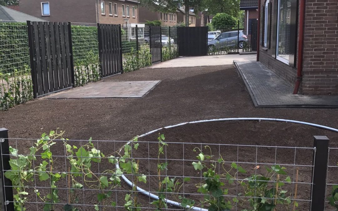 Tuin Apeldoorn, bestraat, omheind, deels beplant en ingezaaid
